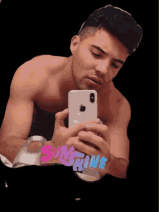 a shirtless man is taking a selfie in front of a mirror with the word sunshine on the bottom right