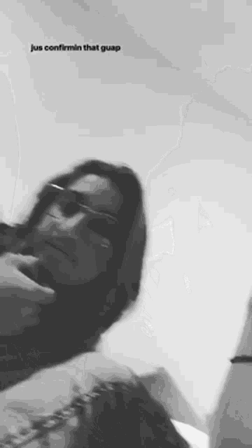a black and white photo of a woman wearing sunglasses and a caption that says jus confirmin that guap .
