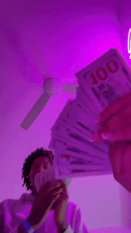 a man is holding a bunch of money in front of a purple background .