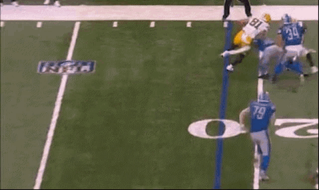 a football player is laying on the field while another player is kneeling on the field .