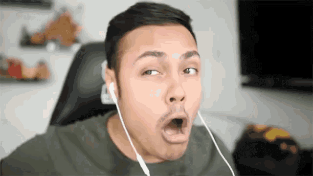 a man wearing headphones making a funny face with his mouth open