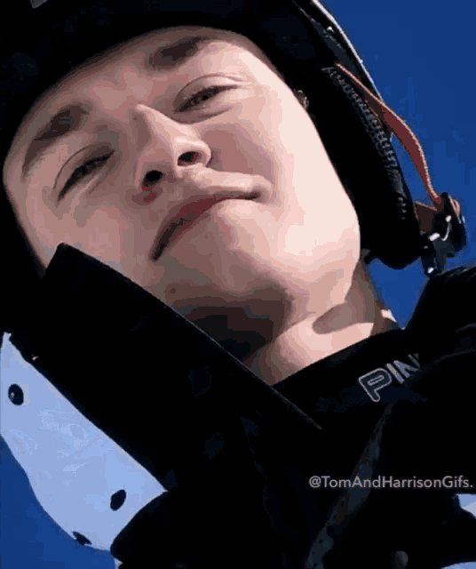 a close up of a person wearing a helmet and a jacket that says ping