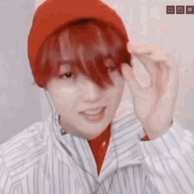 a young man with red hair is wearing a red hat and headphones