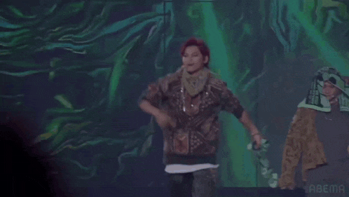 a woman is standing on a stage in front of a green background .