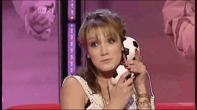 a woman is talking on a soccer ball phone
