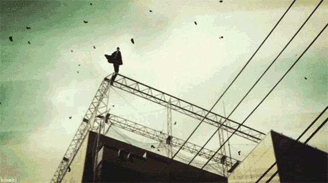 a picture of a man standing on top of a building with kiisaki written below him