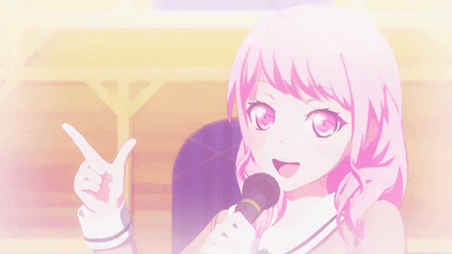 a girl with pink hair is holding a microphone and pointing at something