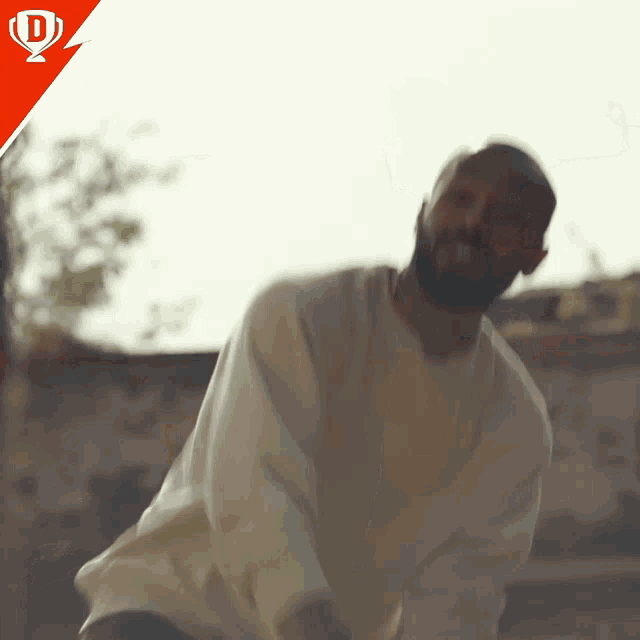 a man in a white sweater is dancing in front of a red speech bubble with the letter d