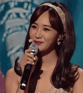 a woman is holding a microphone in her hand and smiling