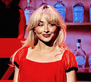 a blonde woman wearing a red dress is smiling