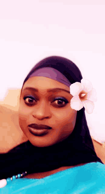 a woman with a flower in her hair is wearing a hijab