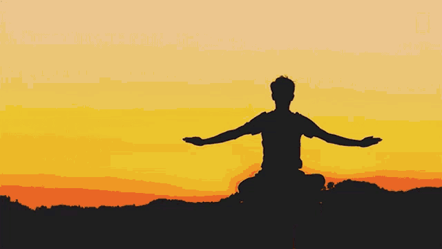 a silhouette of a man sitting in a lotus position with his arms outstretched