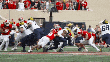 a football player with the number 68 on his jersey is being tackled