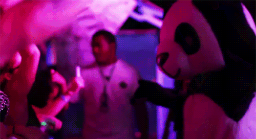 a man in a panda mask stands in front of a crowd at a party