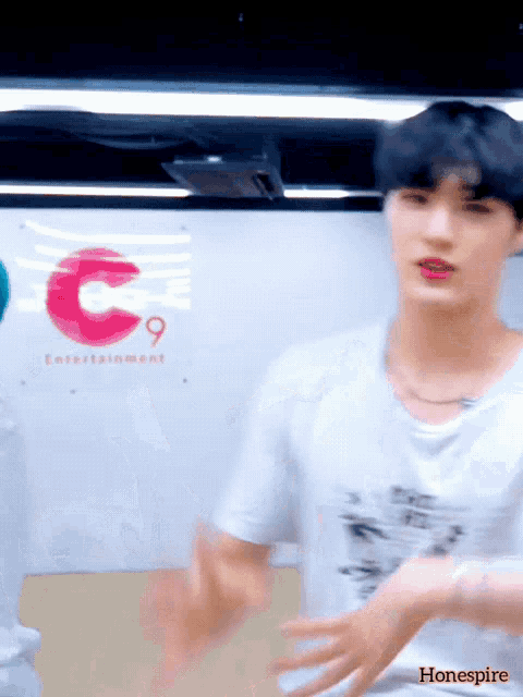 a man in a white shirt is dancing in front of a sign that says entertainment