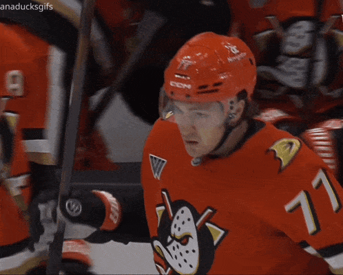 a hockey player wearing a red ccm helmet