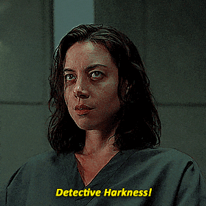 a woman in a grey scrub top says " detective harkness "