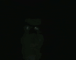 a man wearing glasses and headphones is smiling in a dark room