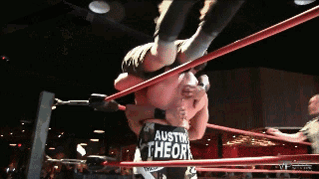 a wrestler wearing a shirt that says " austin theor " is being lifted in the air by another wrestler