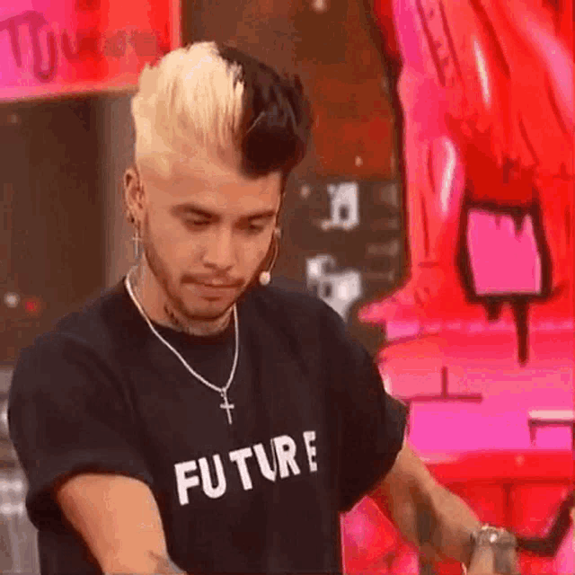 a man with blonde and black hair is wearing a black t-shirt that says `` future '' .