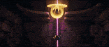 a purple light is coming out of a yellow object in a room .
