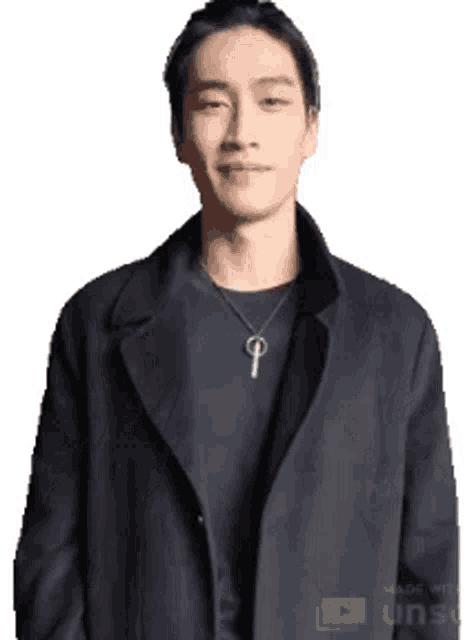 a man is wearing a black coat and a key necklace