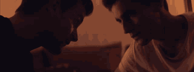 two men are looking at each other with their eyes closed