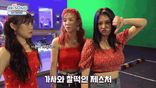three girls are standing in front of a green screen with arisong on it