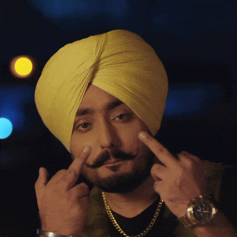 a man with a beard wearing a yellow turban