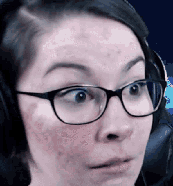 a woman wearing glasses and headphones is making a surprised face