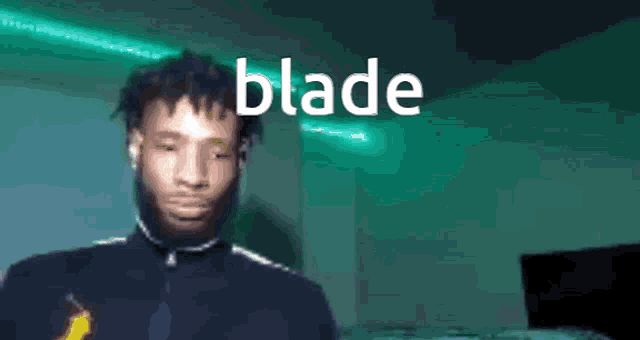 a man is standing in front of a green light and the word blade is visible