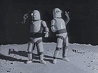 two robots are standing next to each other on a moon .