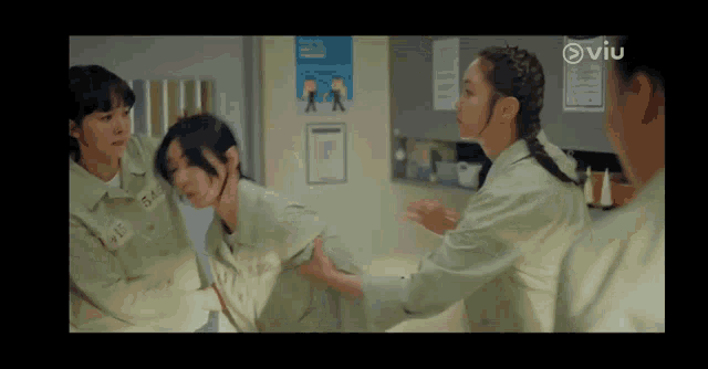 a group of women are standing next to each other in a room in a prison cell .