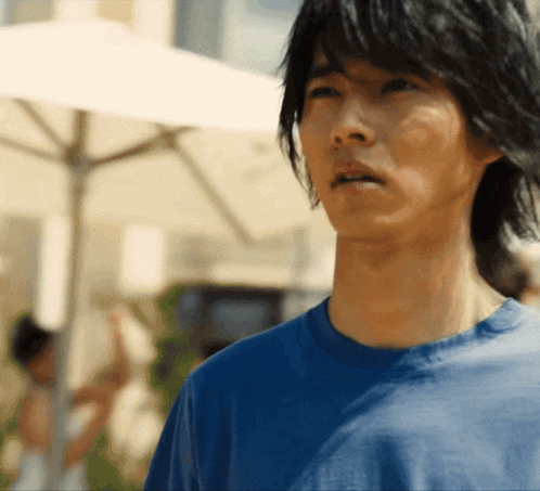 a man in a blue shirt is looking at something