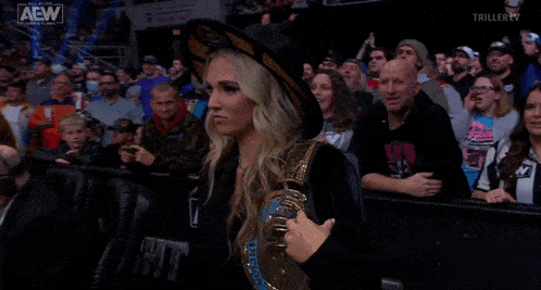 a woman wearing a hat and a belt that says all elite wrestling