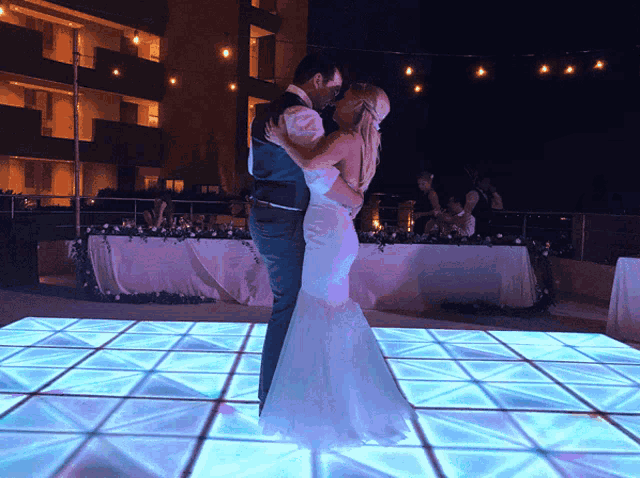 the bride and groom are dancing on a dance floor