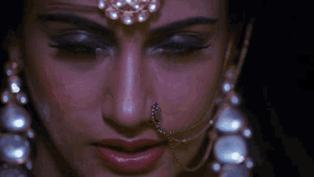 a close up of a woman 's face with red eyes and earrings
