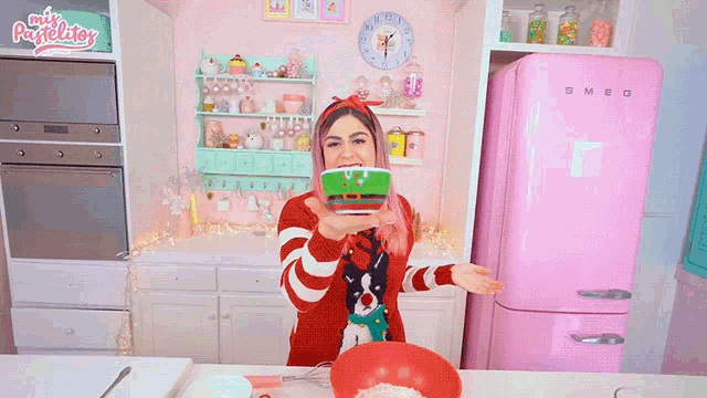 a woman in a kitchen with a smeg refrigerator behind her