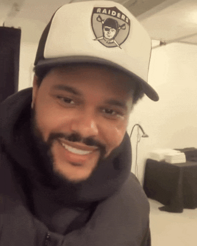 a man with a beard wearing a raiders hat