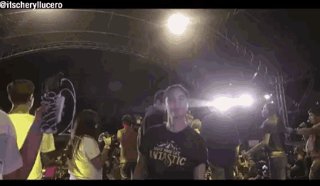 a woman wearing a shirt that says fantastic stands in front of a crowd