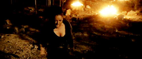 a woman is standing in front of a burning building