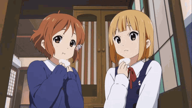 two anime girls are standing next to each other and one is holding a marshmallow