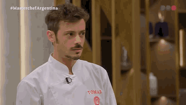 a man in a chef 's coat with the name tomas on it