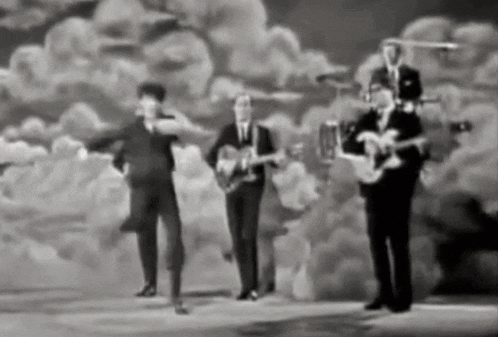 a black and white photo of four men playing guitars