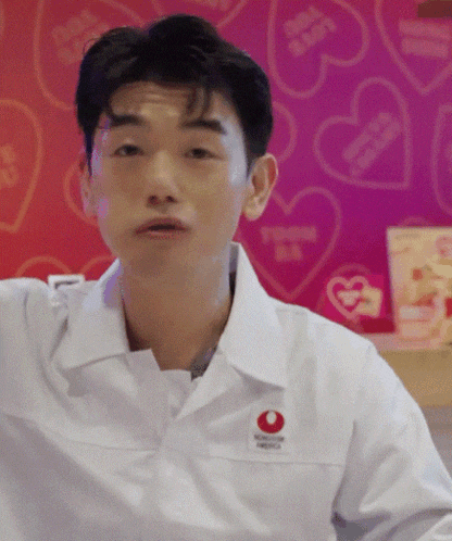 a man wearing a white shirt with a red circle that says i love you