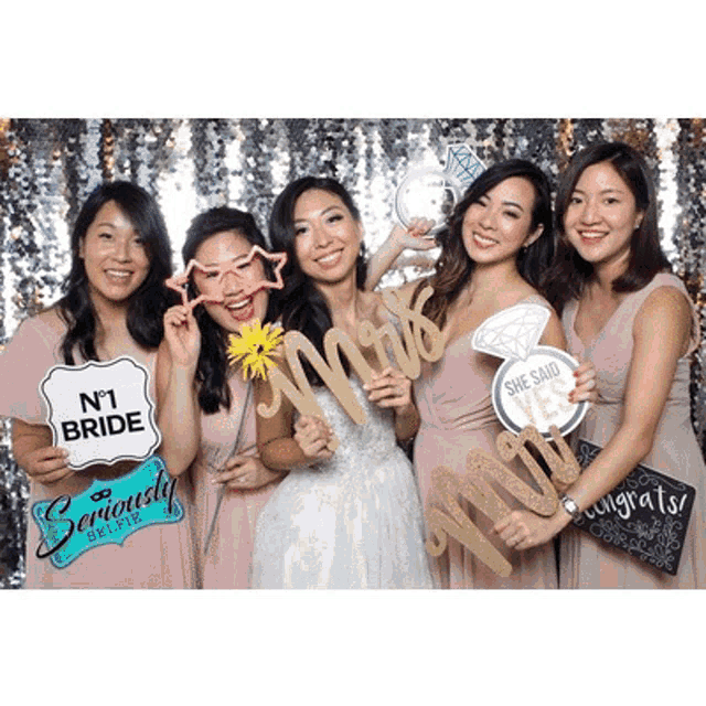 a bride and her bridesmaids are posing for a photo with props