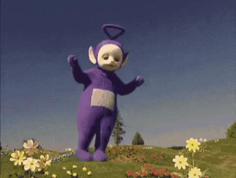 a purple teddy bear is standing in a field of flowers