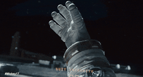 a man in an astronaut 's helmet with the hashtag #mickey17 on the bottom