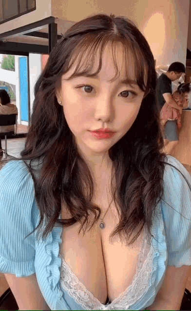 a woman with very large breasts wearing a blue shirt