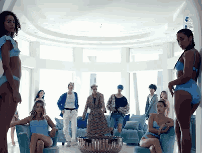 a group of women in blue bikinis are standing in a room